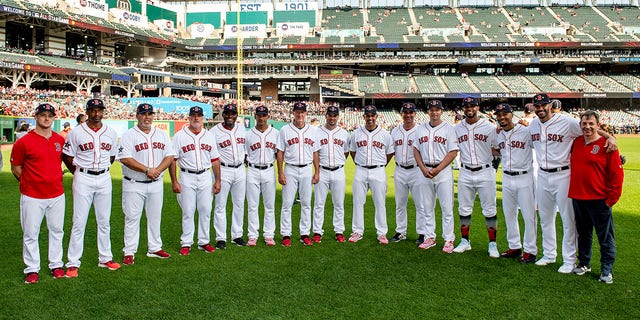 Video coordinator J.T. Watkins, first base coach Tom Goodwin, bullpen coach Craig Bjornson, pitching coach Dana LeVangie, third base coach Carlos Febles, bullpen catcher Mani Martinez, bench coach Ron Roenicke, coach Ramon Vazquez, manager Alex Cora, assistant hitting coach Andy Barkett, hitting coach Tim Hyers, Xander Bogaerts (2) Mookie Betts (50), J.D. Martinez (28) and video coordinator Billy Broadbent of the Boston Red Sox pose for a group photograph before the 2019 MLB All-Star Game at Progressive Field July 9, 2019, in Cleveland. 