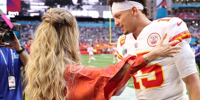 Brittany Mahomes and Patrick Mahomes embrace on the field before Super Bowl LVII at State Farm Stadium on Feb. 12, 2023.