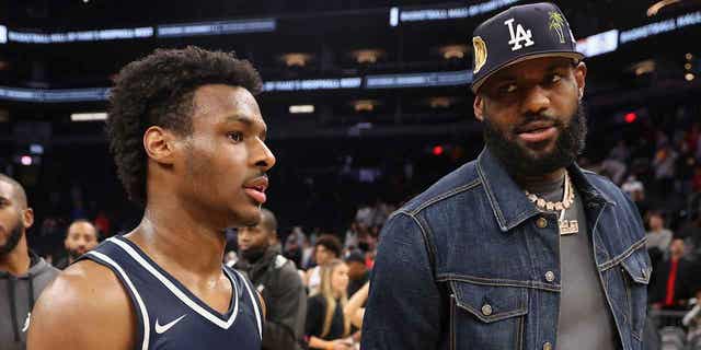 Bronny James stands with his father, LeBron James, following a Sierra Canyon Trailblazers game n Phoenix on Dec. 11, 2021.