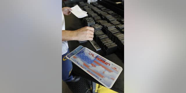 An inmate selects the letters and numbers to be used to make a specialty license plate by Prison Industries at Folsom State Prison, May 15, 2012, in Folsom, Calif. Lawmakers in Nevada and California are advancing legislation to remove involuntary servitude from their state constitutions, a move that follows four states that purged forced labor from the books in ballot measures last fall.