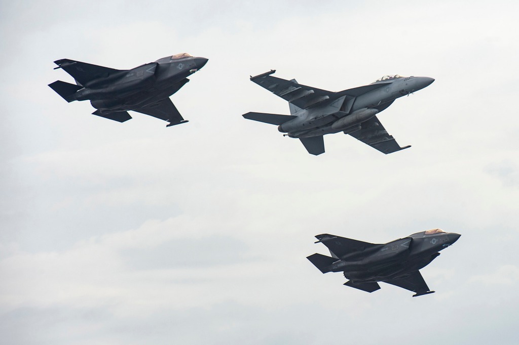 Aircraft from the aircraft carrier USS Nimitz and the USS Makin Island fly in formation past Nimitz in the South China Sea, Sunday, Feb. 12, 2023