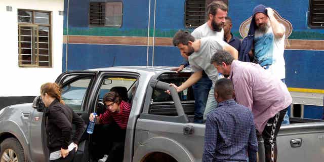 Seven of the eight Croatian nationals charged with attempting to traffic children, outside the magistrates court in Ndola, Zambia, Tuesday, Jan. 10, 2023. The eight have pleaded not guilty to the charge of child trafficking before a magistrate.