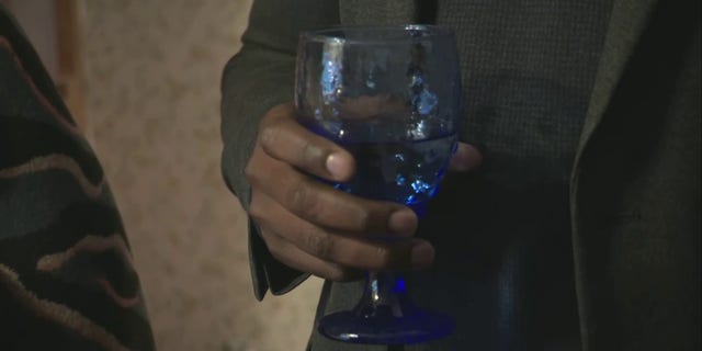 EPA Administrator Michael Regan holds a glass of tap water inside a woman's East Palestine, Ohio home, Tuesday, Feb. 21, 2023.