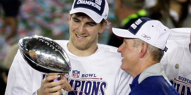 This Feb. 3, 2008, file photo shows New York Giants quarterback Eli Manning, left, and his coach Tom Coughlin looking at the Vince Lombardi Trophy as they celebrate after the Giants beat the New England Patriots 17-14 in Super Bowl XLII in Glendale, Ariz. 