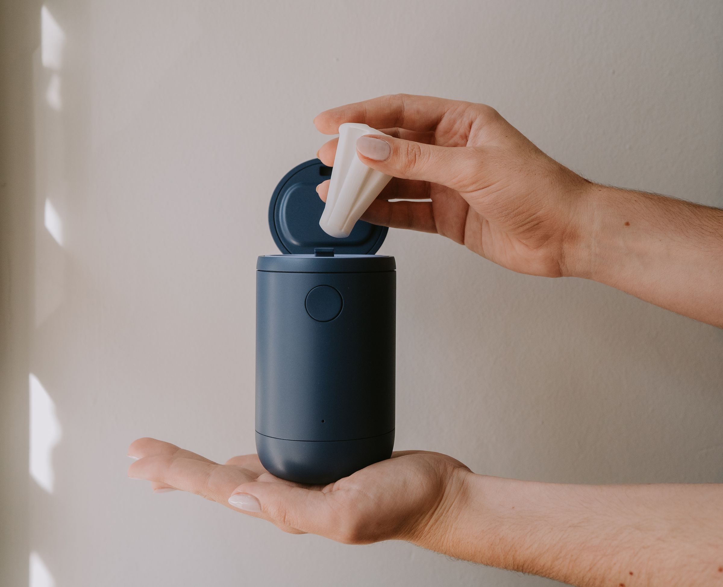 Person placing Emm cup inside the portable UV sanitizing case