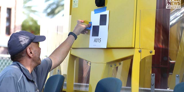 Representatives Austrian ride manufacturer, Funtime Handels inspect the Freefall drop tower ride at Icon Park in Orlando Florida, Thursday, February, 23, 2023. Ride goer, Tyree Sampson died when he fell from the ride in March last year. A man tapes a numbered marker to the ride for the inspection. 