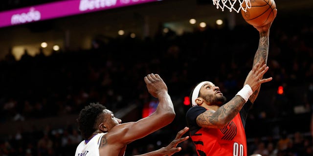 Gary Payton II (00) of the Portland Trail Blazers shoots against Thomas Bryant of the Los Angeles Lakers during the third quarter at Moda Center Jan. 22, 2023, in Portland, Ore.