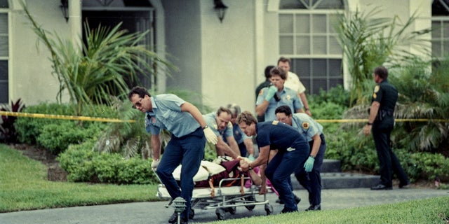 Paramedics take Marlene Warren to an ambulance on May 26, 1990, after she was shot in front of her home in Wellington, Florida.