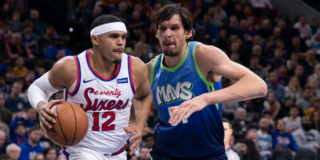 Tobias Harris (12) of the Philadelphia 76ers dribbles the ball against Boban Marjanovic (51) of the Dallas Mavericks at the Wells Fargo Center Dec. 20, 2019, in Philadelphia. 