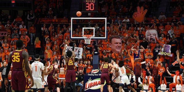 Minnesota Golden Gophers center Daniel Oturu, #25, shoots a free throw with the Illinois Orange Crush student section holding signs behind the basket during a college basketball game between the Minnesota Golden Gophers and Illinois Fighting Illini on Jan. 30, 2020 at the State Farm Center in Champaign, Illinois.