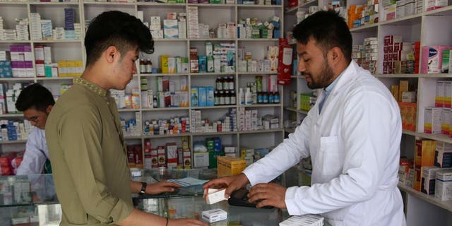 A customer buys medicines from a pharmacy in Kabul, Afghanistan, Sept. 29, 2020.