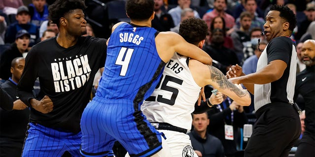 Mo Bamba. #11 of the Orlando Magic (L), throws a punch as teammate Jalen Suggs, #4, gets into a scrum with Austin Rivers, #25 of the Minnesota Timberwolves, in the third quarter of the game at Target Center on February 3, 2023, in Minneapolis, Minnesota. Rivers, Bamba, and Suggs were ejected from the game. 