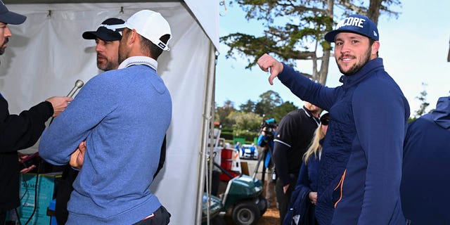 Buffalo Bills quarterback, Josh Allen, gives a thumbs down, while Green Bay Packers quarterback, Aaron Rodgers is interviewed during the continuation of the third round of the AT&amp;amp;T Pebble Beach Pro-Am at Pebble Beach Golf Links on February 5, 2023 in Pebble Beach, California.