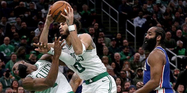 Jayson Tatum, #0 of the Boston Celtics, collides with Jaylen Brown, #7, as James Harden, #1 of the Philadelphia 76ers, looks on during the first half of the NBA game at the TD Garden on Feb. 8, 2023 in Boston.