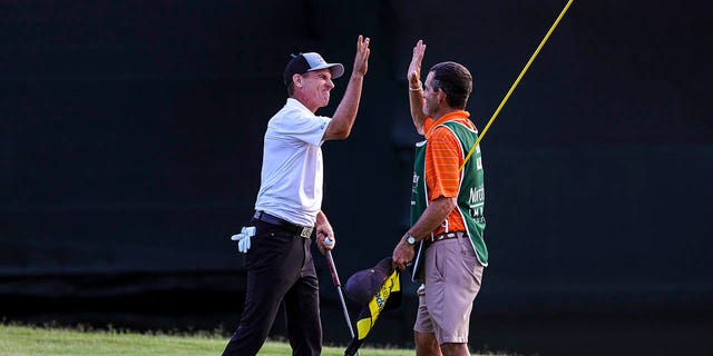 Steven Alker of New Zealand celebrates on the 18th hole with his caddie, Sam Workman, after winning the Insperity Invitational at The Woodlands Golf Club on May 1, 2022, in The Woodlands, Texas. 
