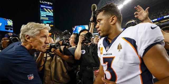 Head coach Pete Carroll of the Seattle Seahawks and Russell Wilson, #3 of the Denver Broncos, shake hands after their game at Lumen Field on September 12, 2022, in Seattle, Washington. 