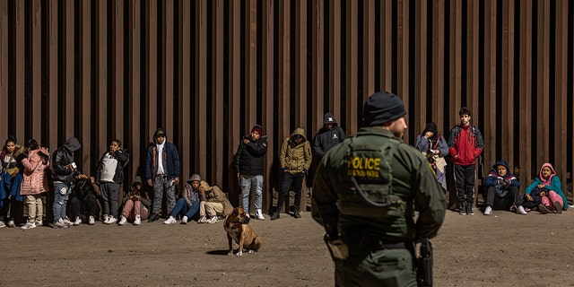 Immigrants wait to be processed by the U.S. Border Patrol after crossing the border from Mexico on December 30, 2022, in Yuma, Arizona. 