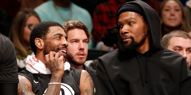 Kyrie Irving #11 (L) and Kevin Durant #7 of the Brooklyn Nets look on against the Los Angeles Lakers at Barclays Center on January 30, 2023 in New York City. 