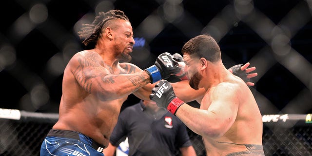 Greg Hardy (L) and Tai Tuivasa of Australia exchange punches in the first round in their heavyweight bout during UFC 264: Poirier vs. McGregor 3 at T-Mobile Arena on July 10, 2021, in Las Vegas, Nevada.