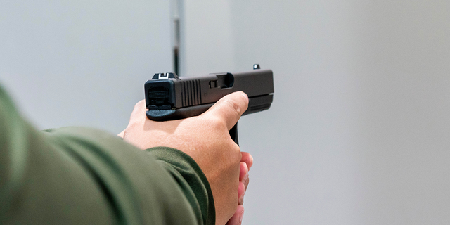 A customer holds a Glock 17 pistol for sale at Redstone Firearms, in Burbank, California, US, on Friday, Sept. 16, 2022. 