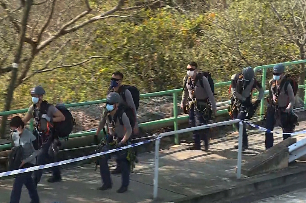 police officers prepare to conduct a search on a hillside following a murder case of a model, in Hong Kong on Sunday, Feb. 26, 2023.