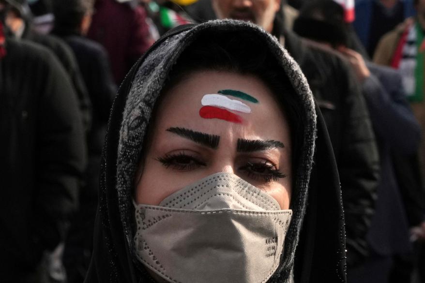 A woman with forehead painted with the Iranian flag's colors takes part in the annual rally commemorating Iran's 1979 Islamic Revolution, in Tehran, Iran, Saturday, Feb. 11, 2023. Iran on Saturday celebrated the 44th anniversary of the 1979 Islamic Revolution amid nationwide anti-government protests and heightened tensions with the West. (AP Photo/Vahid Salemi)