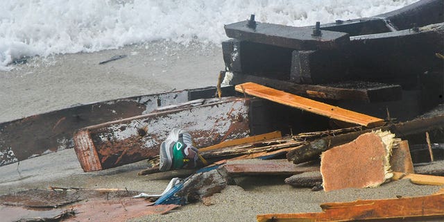 Shoes seen among the wreckage of a migrant boat washed ashore at a beach near Cutro, southern Italy, Sunday, Feb. 26, 2023. 