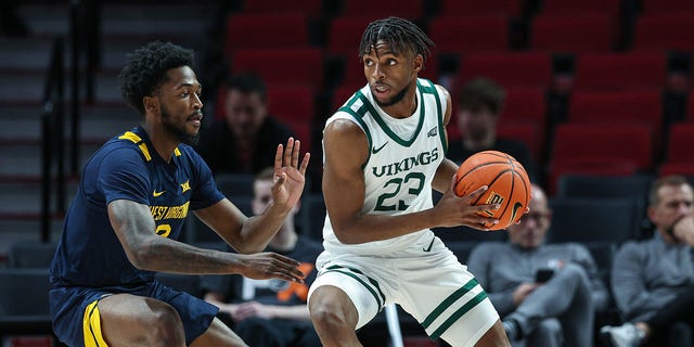 Jorell Saterfield (23) of the Portland State Vikings handles the ball against Kobe Johnson (2) of the West Virginia Mountaineers at Moda Center Nov. 25, 2022, in Portland, Ore.