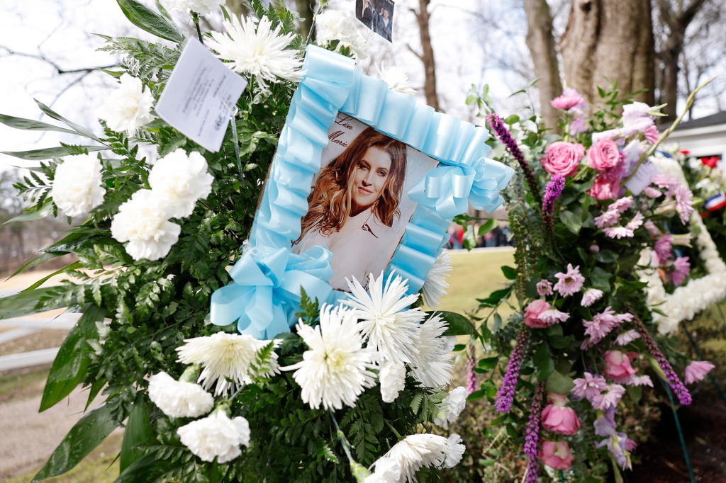 A photo of Lisa Marie Presley during her memorial service. The photo is surrounded by flowers. 