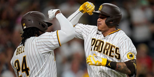 The San Diego Padres' Manny Machado, right, celebrates with Josh Bell after hitting a home run against the Colorado Rockies during the fifth inning of a game at Petco Park in San Diego on Aug. 3, 2022. 