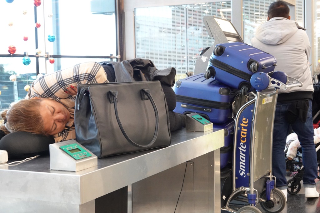 A homeless woman sleeping at the airport.