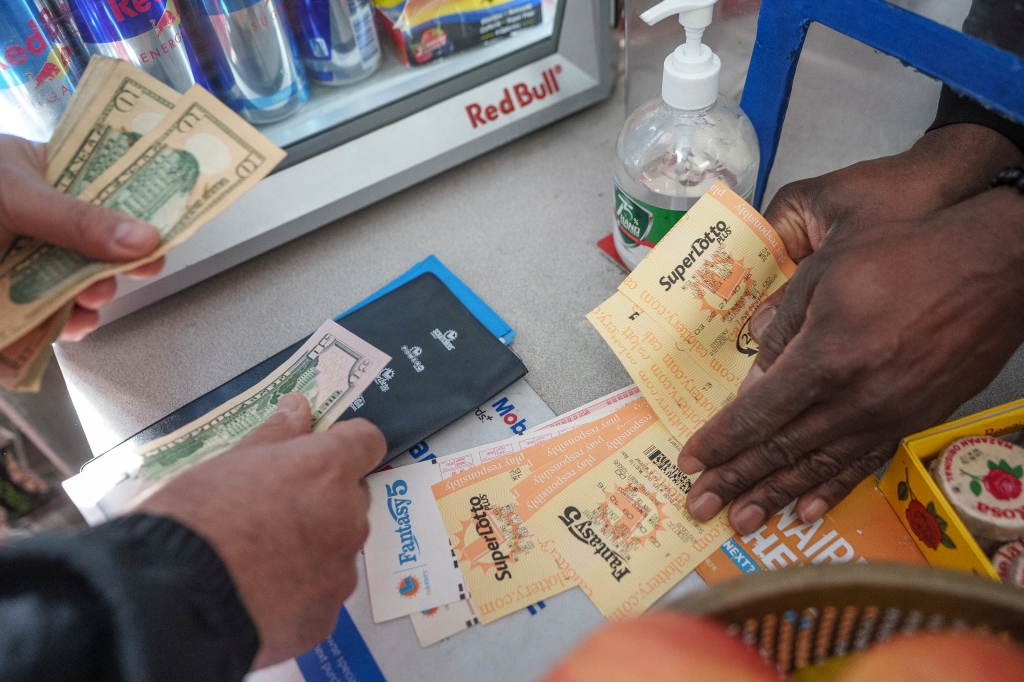 People buy SuperLotto tickets at the Mobil gas station that previously sold the $2.04 billion-winning Powerball ticket award at Joe's Service Center 