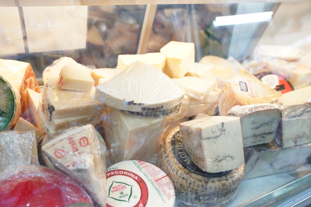 A pile of cheese in the store window.