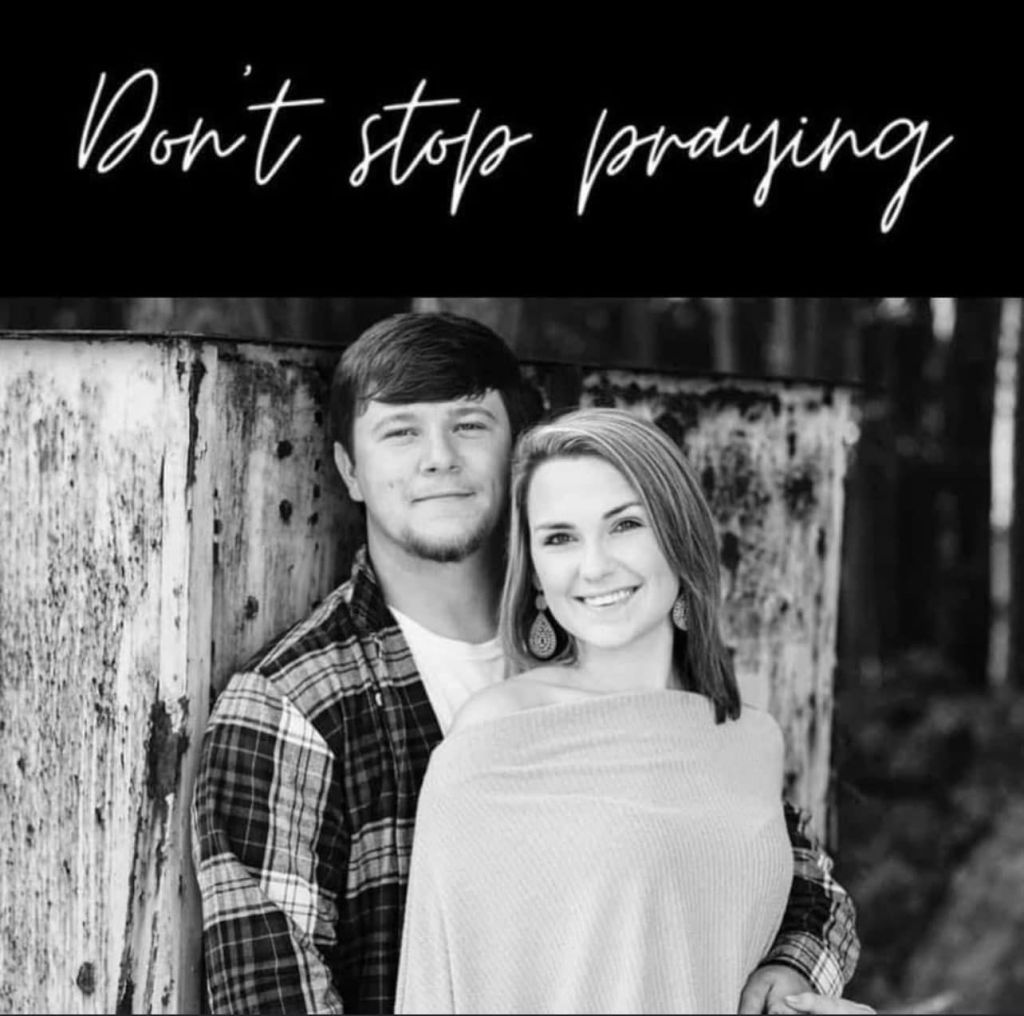 A black-and-white photo of Tyler Doyle with his wife, captioned with the words "Don't stop praying."