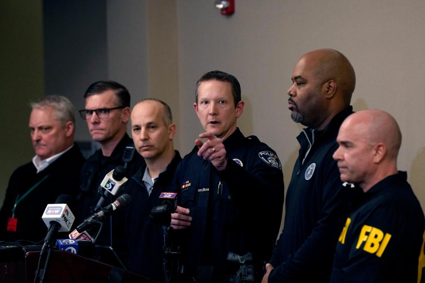 Michigan State University Interim Deputy Police Chief Chris Rozman, center, joins law enforcement officials while addressing the media.