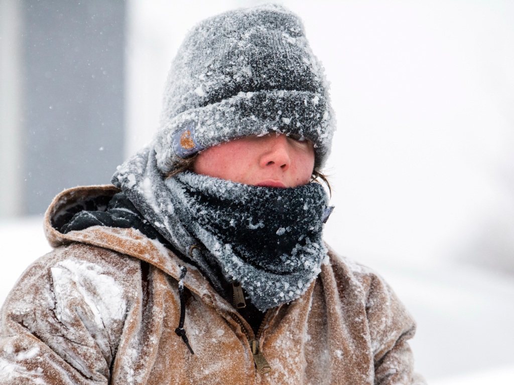 A worker covered in frozen winter clothes outside in Nebraska.