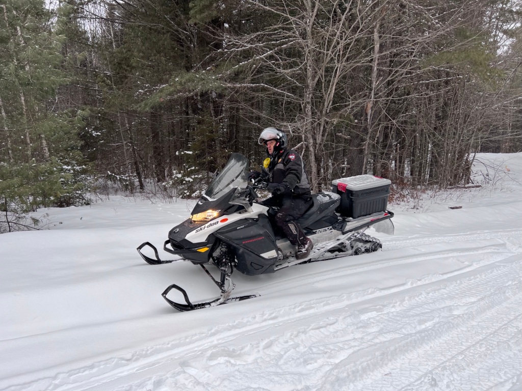 Maine Game Warden Brad Richard on his snowmobile.