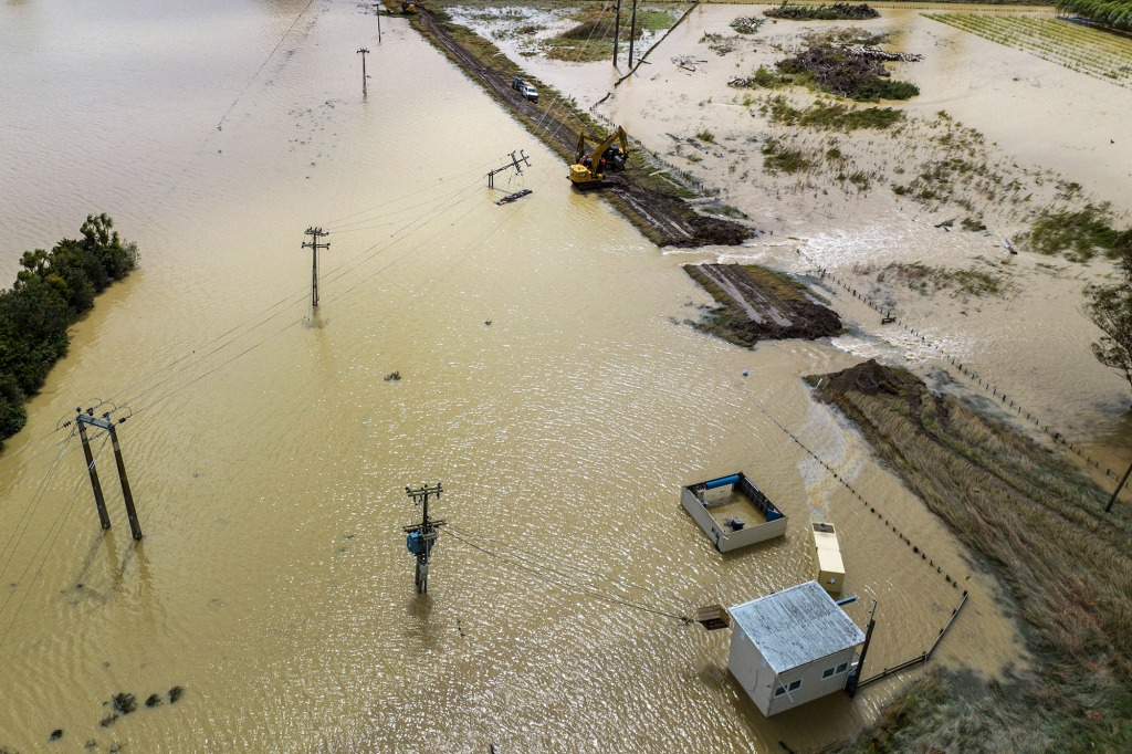 Workers clear the mud and debris from the Redclyffe Substation following Cyclone Gabrielle, in Napier on February 17, 2023.