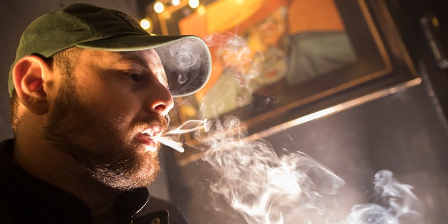 A man smokes marijuana in New York. New Yorkers can possess and use up to 3 ounces of cannabis under a legalization bill.