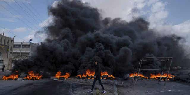 Palestinian protesters block the main road with burning tires in the West Bank city of Jericho, Monday, Feb. 6, 2023. Israeli forces killed five Palestinian gunmen in a raid on refugee camp in the occupied West Bank on Monday, the latest bloodshed in the region that will likely further exacerbate tensions. (AP Photo/Nasser Nasser)