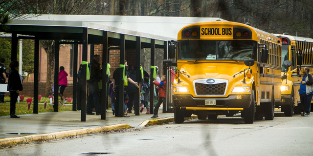 Students exit a school bus during the first day back to Richneck Elementary School on Monday Jan. 30, in Newport News, Virginia. 