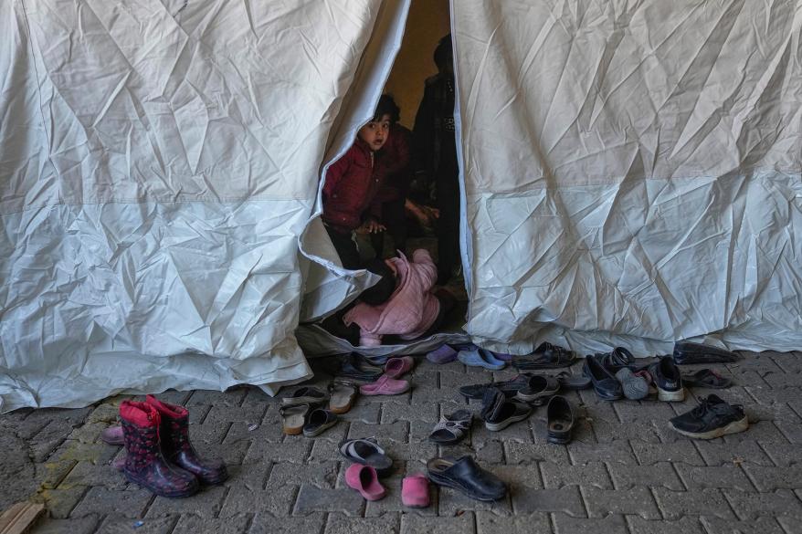 A Syrian child looks on from inside a tent used as a shelter in a public market space in Islahiye District of Gaziantep, southern Turkey, Saturday, Feb. 11, 2023.