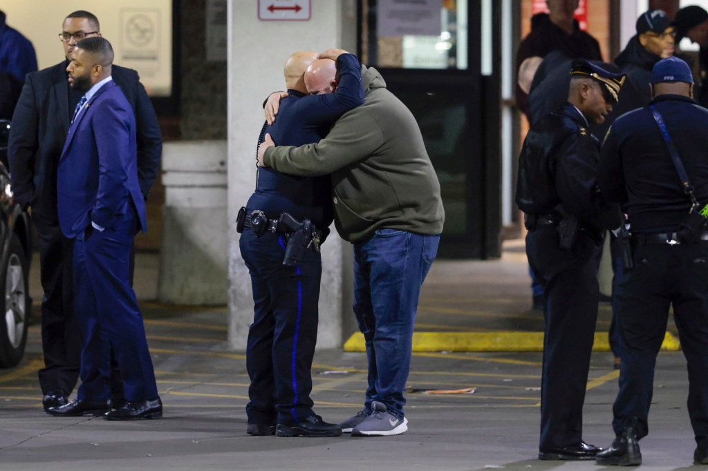 Police embrace each other at Temple University Hospital following the fatal shooting.