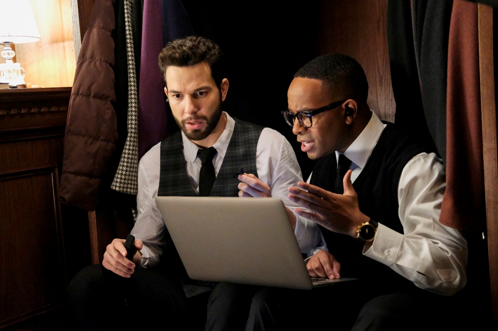 Photo of Todd and his officemate, Lyle. They're sitting side by side in front of a laptop; Todd looks surprised and Lyle is gesturing with his right arm at the computer.