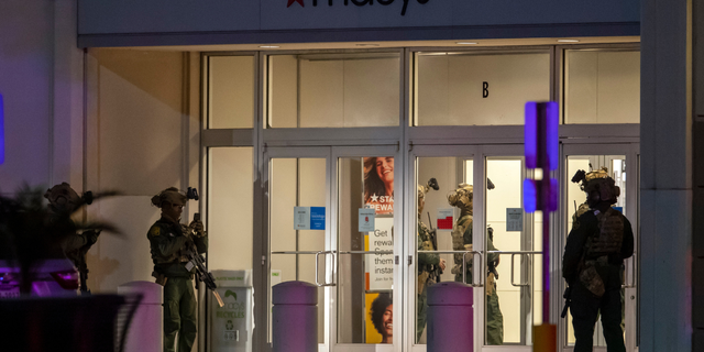 Police officers stand guard at an entrance of a shopping mall, Wednesday, Feb. 15, 2023, in El Paso, Texas. Police say one person was killed and three other people were wounded in a shooting at Cielo Vista Mall. One person has been taken into custody, El Paso police spokesperson Sgt. Robert Gomez said.