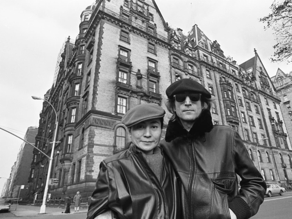 John Lennon (1940 - 1980) and Yoko Ono, both in leather jackets and berets, as they pose outside the Dakota Apartments, where they lived, New York, New York, November 21, 1980.