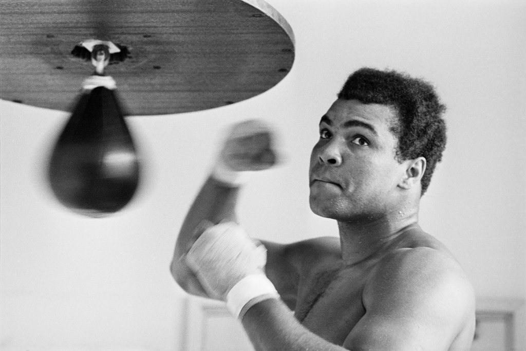 Muhammad Ali punching a punching bag. 