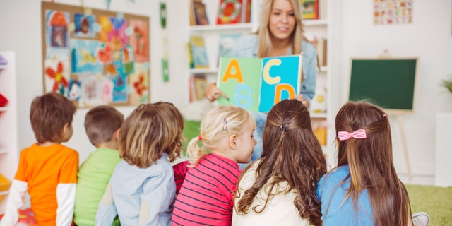 Teacher with a group of preschool children in a nursery.