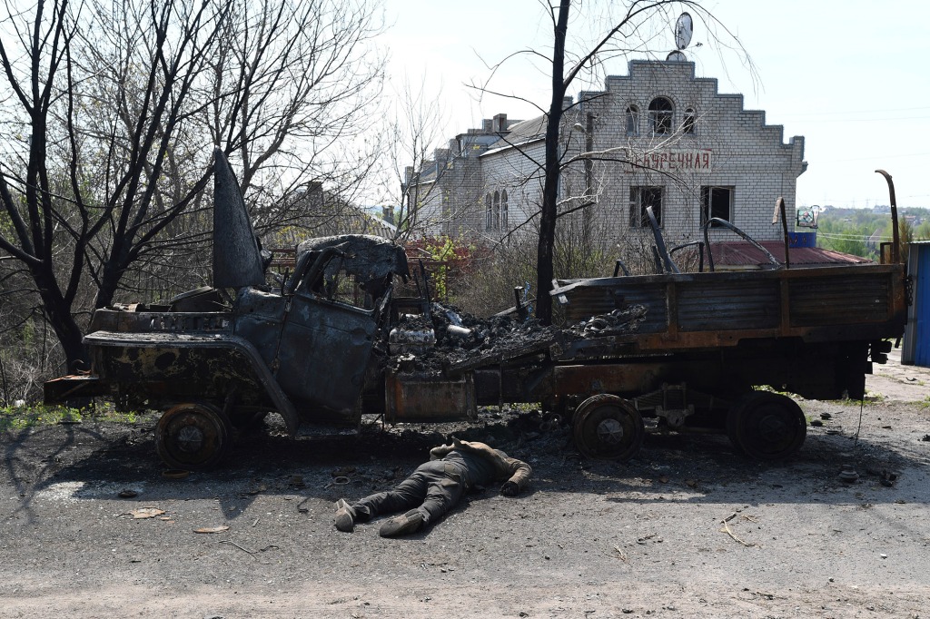 Body of Russian soldier next to burned truck