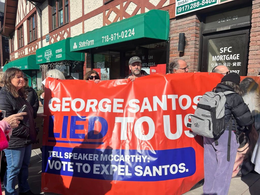 Protesters march on Santos' Long Island office Wednesday.